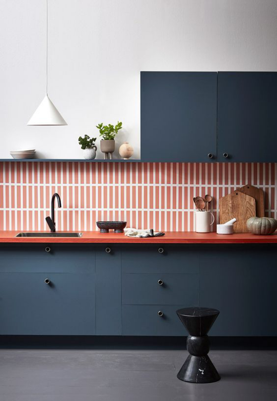 Küchenzeile moderne Ausführung straker Farbkontrast Dunkelblau Orange gestreifte Wandfliesen Holzbretter