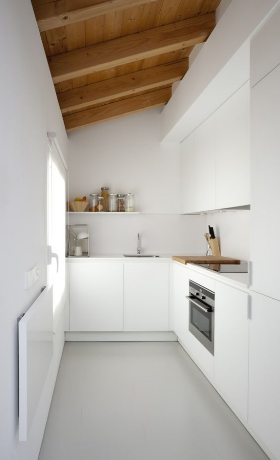 L-Küche ganz in Weiß unter der Dachschräge Holzbalken enger Raum Fenster links