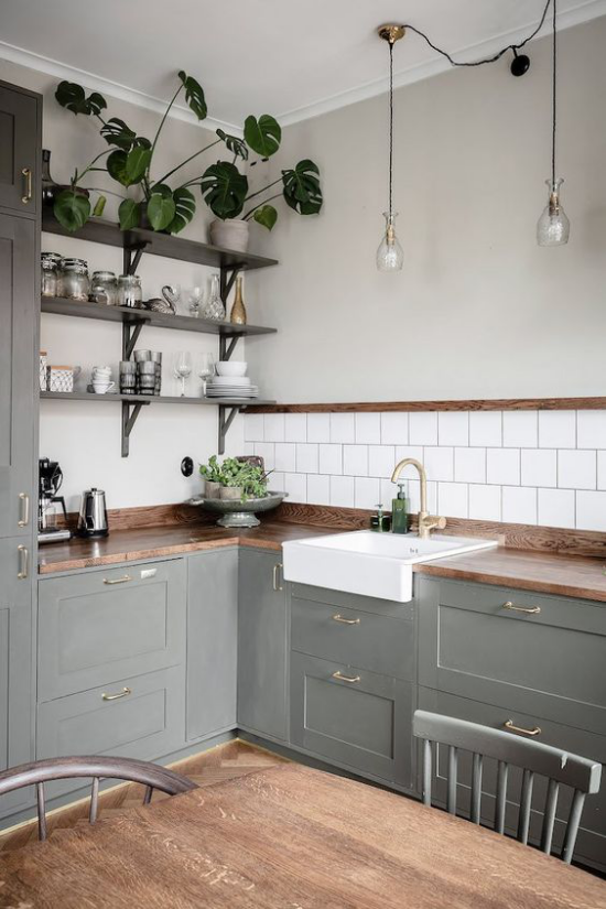 L-Küche in Retro Stil graue Unterschränke weiße Fliesen Küchenrückwand Holzregale grüne Topfpflanzen