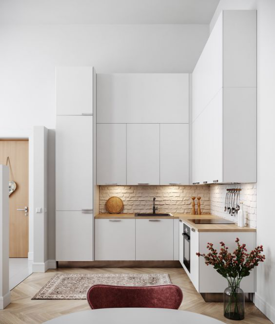 L-Küche kleine Ecke Ziegelwand gut beleuchtet sehr elegante weiße Küche Teil des offenen Wohnkonzeptes