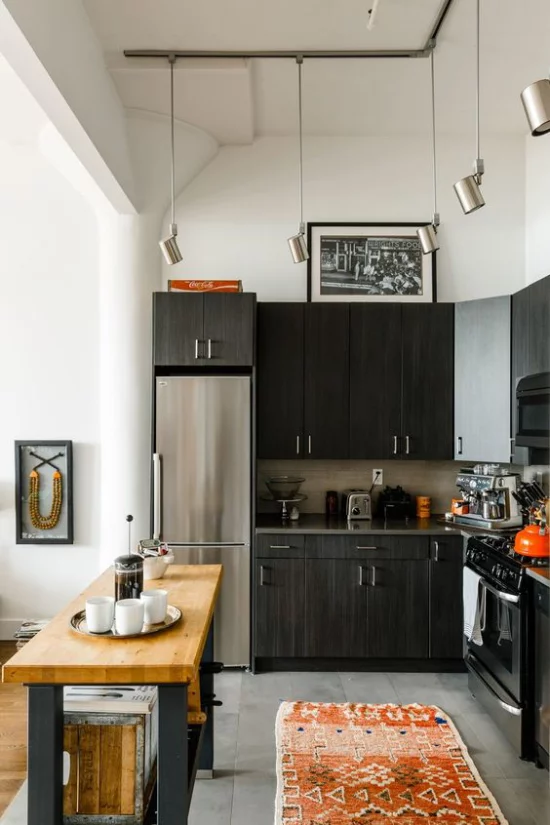 L-Küche moderne Küchengestaltung in L-Form dunkelbraune Schränke silberner Kühlschrank Esstisch daneben