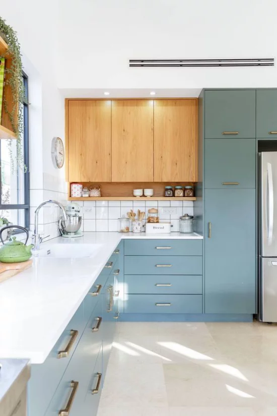 L-Küche schöne Gestaltung hellblaue Unterschränke weiße Arbeitsplatte Oberschränke aus Holz weiße Fliesen