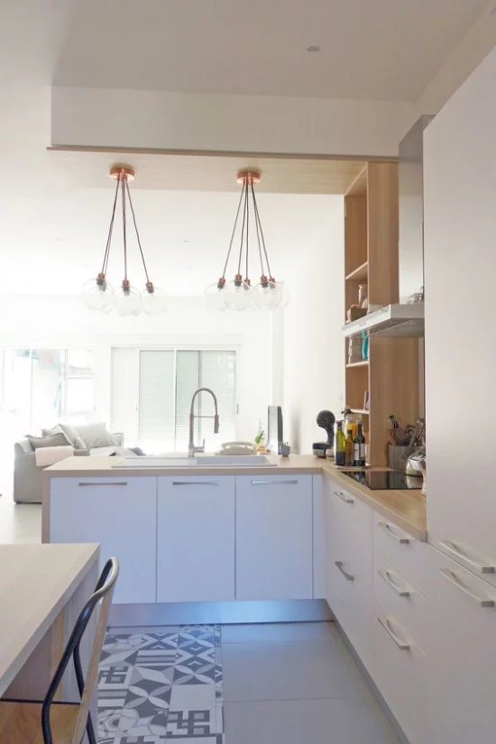 L-Küche schönes Design integriert ins moderne Wohnzimmer weiße Schränke helles Holz Tisch Hängelampen