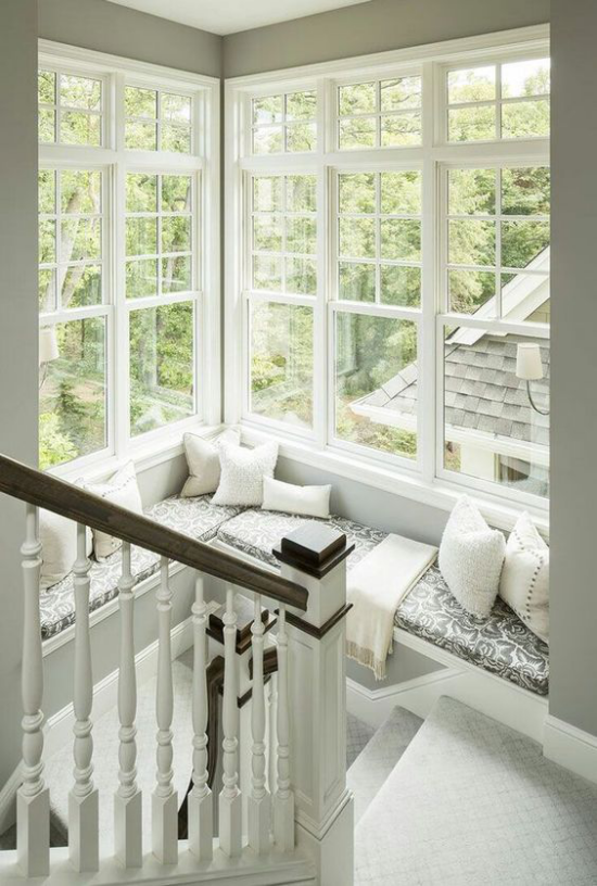 Platz am Eckfenster clever nutzen im Treppenhaus gemütliche Sitzecke einrichten in Weiß und Grau