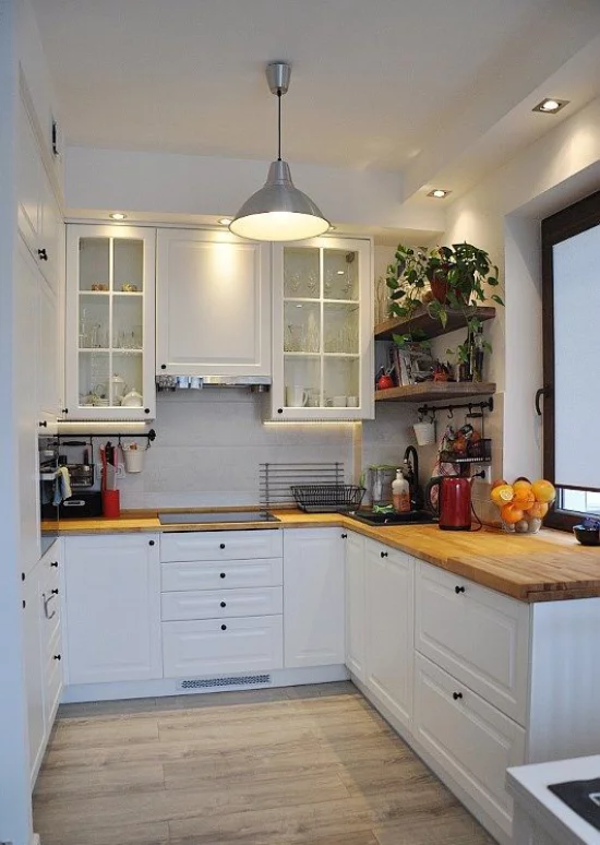 U-Küche eingebaute Beleuchtung Strahler Deckenleuchte weiße Unterschränke Holzarbeitsplatten Regale mit Topfpflanzen