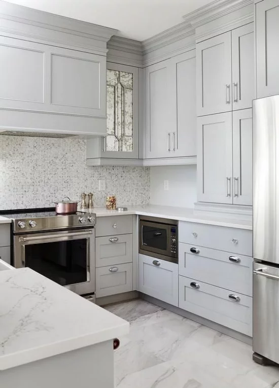 U-Küche hohe graue Oberschränke viel Stauraum Arbeitsplatten aus weißem Marmor