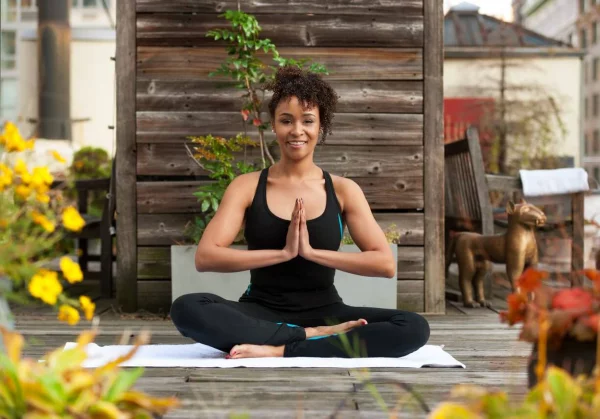 Yoga Garten anlegen und gestalten Yoga praktizieren junge Frau inmitten von viel Gartengrün ruhige Atmosphäre