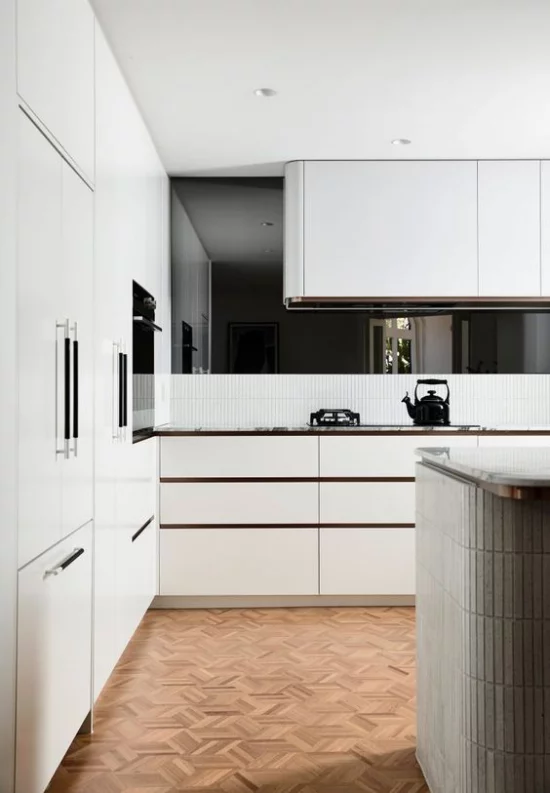 integrierte Dunstabzugshaube elegante weiße Küche kleine schwarze Akzente setzen
