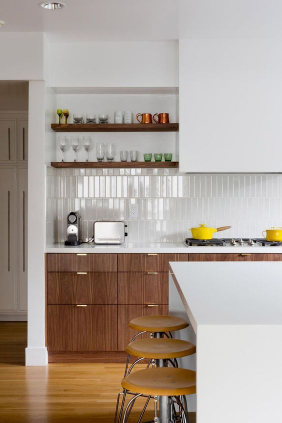 integrierte Dunstabzugshaube weiß dominiert Rückwand aus weißen Fliesen Schränke Kücheninsel
