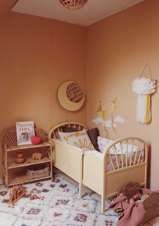 zeitlose Farben gemütliches Babyzimmer in Erdfarben in Retro Stil Bett Teppich Kommode