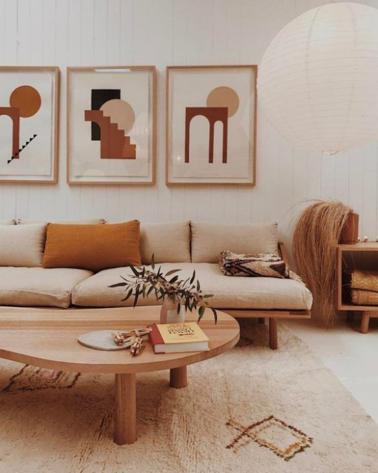 zeitlose Farben gemütliches Wohnzimmer in warmen Erdnuancen weiß beige gebrannte Siena  Sofa Teppich Wanddekoration runder niedriger Holztisch