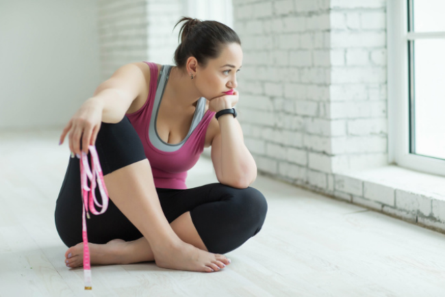 Diätfallen junge Frau verzweifelt beim Sport der Weg zum Wunschgewicht ist schwer
