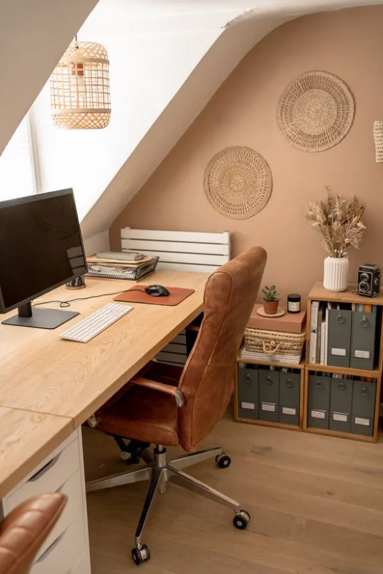 Heimbüro auf dem Dachboden beigefarbene Akzentwand helles Holz Sessel mit Samt überzogen handgemachte Wanddekoration