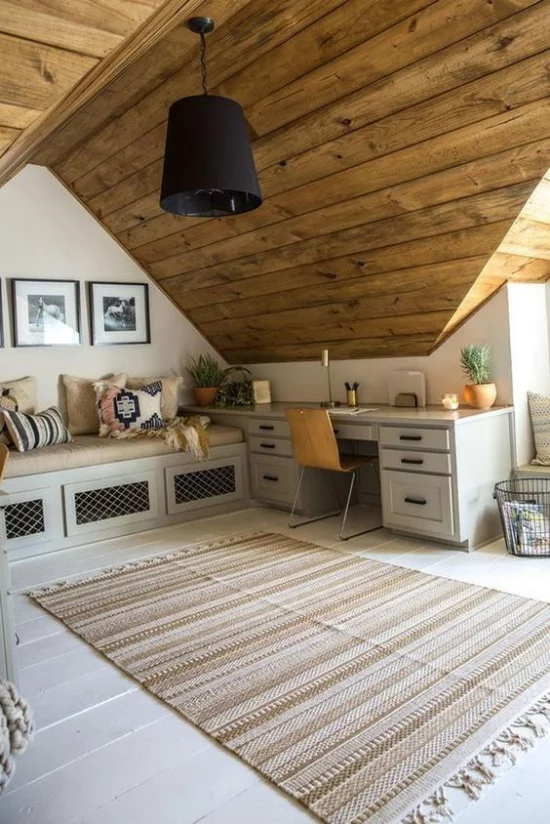 Heimbüro auf dem Dachboden sehr gemütliches und romantisches Ambiente viel Holz weiche Textilien Kissen auf der Sitzbank Teppich