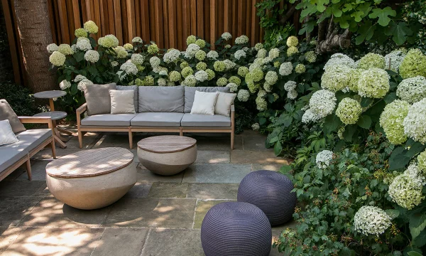 Hortensien zum Blühen bringen Sitzecke im Freien schicke Outdoor-Möbel weiße Hortensienblüten im Halbschatten