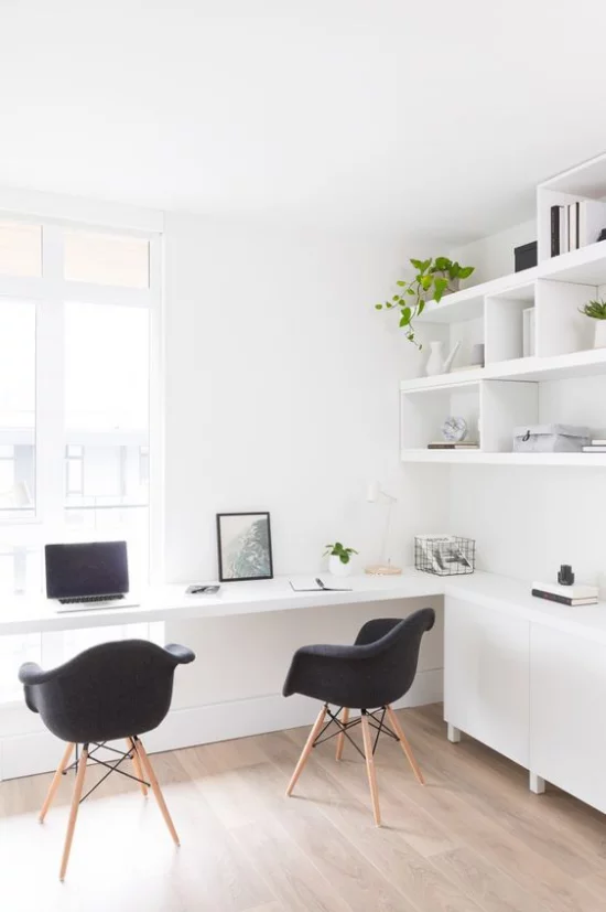 zeitgenössisches Home Office ansprechendes Ambiente Weiß dominiert Fenster Licht zwei schwarze Sessel als Kontrast