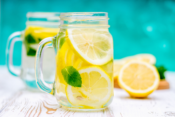 erfrischende Sommergetränke Zitronenwasser eine Kanne pures Wasser mit Scheiben Zitrone Minze Blätter