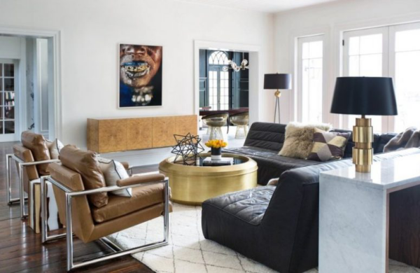 modernes Wohnzimmer eklektisches Raumdesign Ledersessel schwarzes Ledersofa goldglänzender runder Tisch in der Mitte Wandbilder zu viele Farben