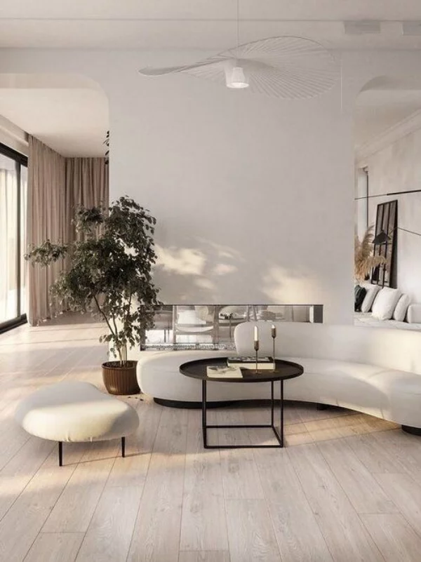 modernes Wohnzimmer weißes Interieur gerundete Möbel Sofa Hocker kleiner Kaffeetisch Trennwand in Weiß grüne Topfpflanze