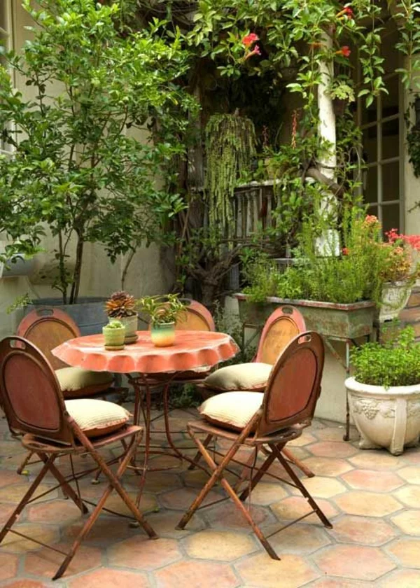 kleine Terrasse mit frischer Tischdeko und vielen Pflanzen