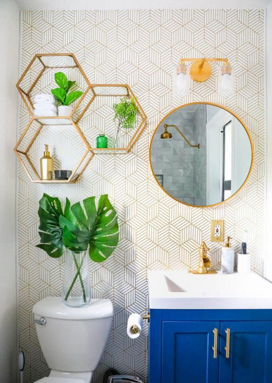 Goldene Akzente im Interieur auffällige Badgestaltung grüne Blätter als Blickfang Regal aus goldenem Metall darüber