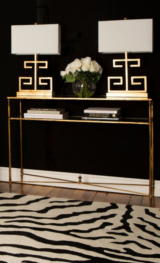 Goldene Akzente im Interieur erstaunliche Gestaltung Beistelltisch im Flur zwei Lampen Vase mit weißen Rosen vor einer schwarzen Wand