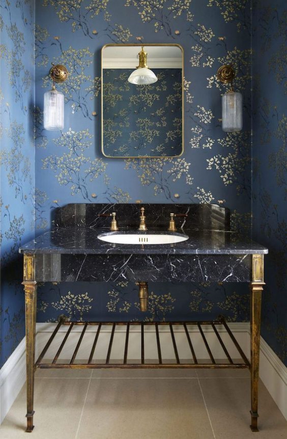 Goldene Akzente im Interieur schickes Bad dunkelblaue Wand gemusterte Tapete Waschtisch aus schwarzem Marmor