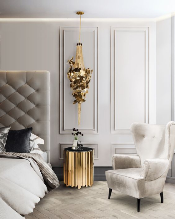 Goldene Akzente im Interieur stilvoll gestaltetes Schlafzimmer alles in Grau und Beige kleiner Beistelltisch als Hingucker in Goldgelb