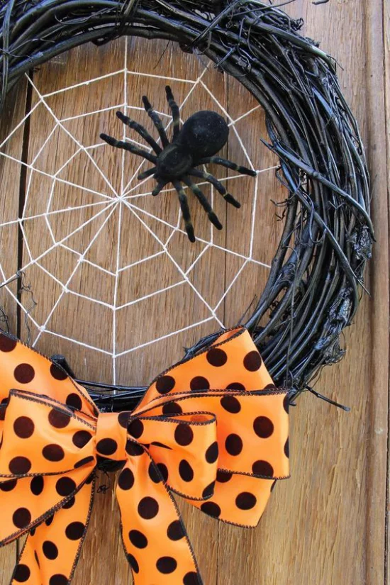 Halloween Kränze schickes Design Kranz aus schwarzen Zeigen Spinne Spinnennest große orange Schleife