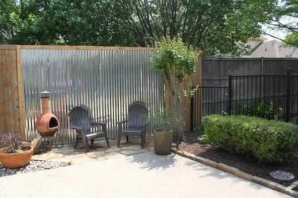 clevere Sichtschutz Ideen für den Garten Zaun aus Holz kleiner Ofen zwei Stühle grüne Pflanzen 