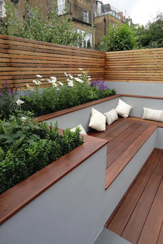minimalistische Terrassengestaltung Holzboden Holzbank blühende Pflanzen ringsum