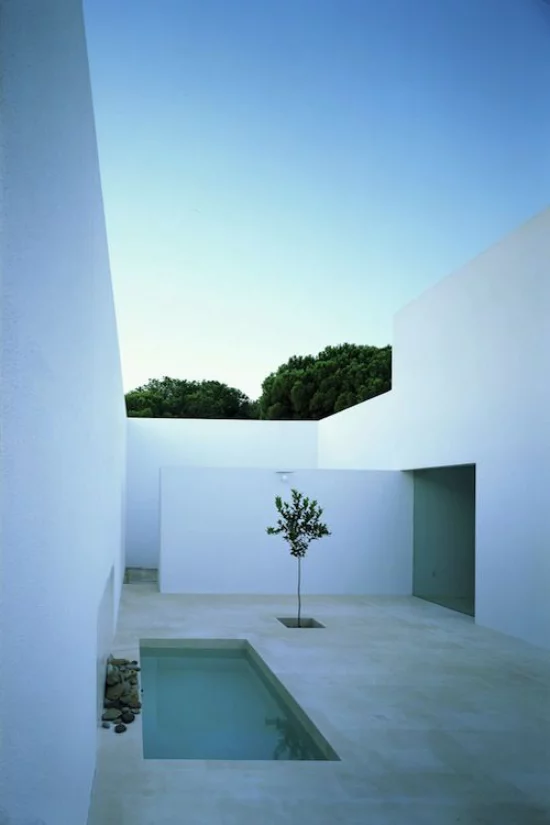 minimalistische Terrassengestaltung Minimalismus pur weiße Wände Sichtschutz Betonboden kleiner Pool ein Baum daneben