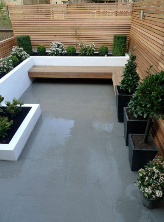 minimalistische Terrassengestaltung kleine Terrasse in der Stadt Betonboden klare Linien Kübel grüne Pflanzen