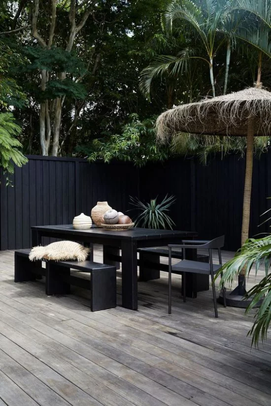 minimalistische Terrassengestaltung schwarze Möbel Wände Holzboden helle Deko Artikel