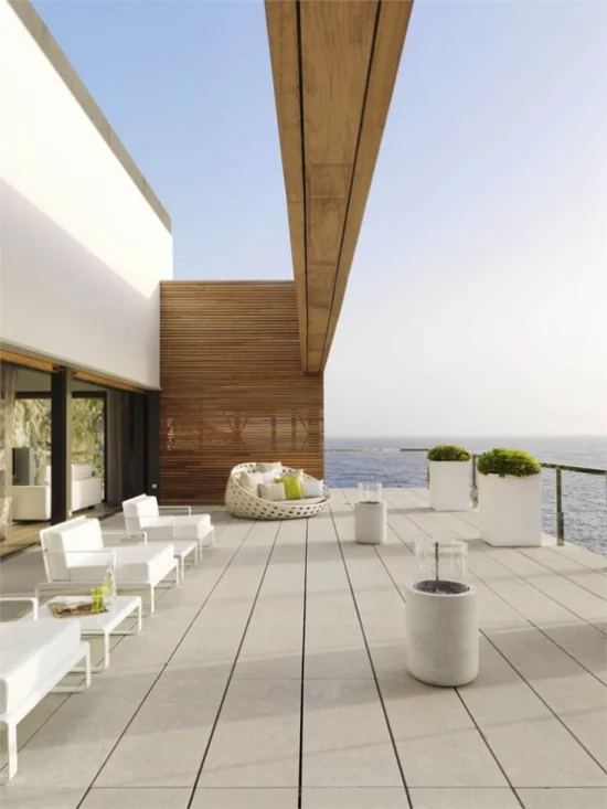 minimalistische Terrassengestaltung weite Terrasse einfaches Gestaltungskonzept helle Farben weiße Pflanzkübel herrliche Ozeansicht
