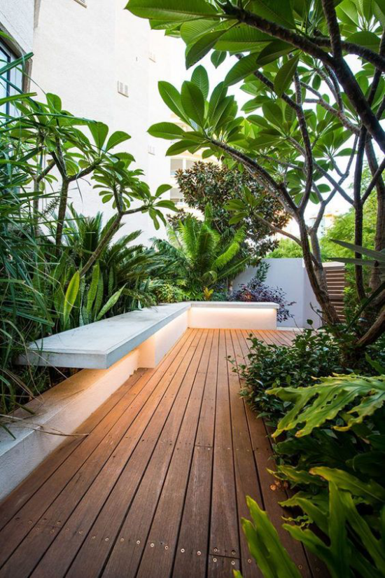 minimalistische Terrassengestaltung üppiges sattes Grün umrahmt die Veranda im minimalistischen Stil