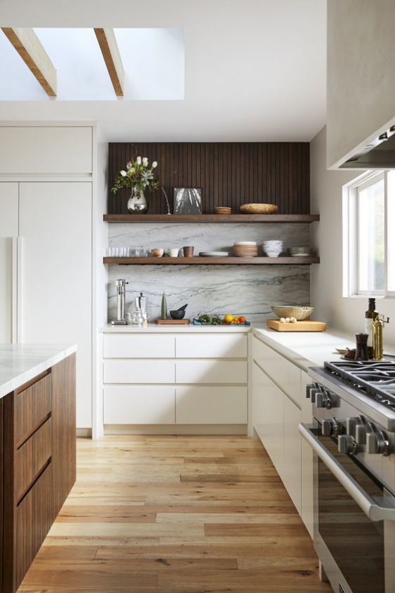 moderne Küche elegantes L-förmiges Küchendesign Fenster weißer Marmor weiße Schränke dunkles Holz