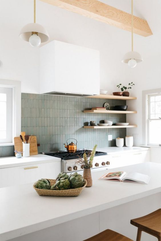 moderne Küche graublaue Fliesen an der Küchenrückwand weiße Schränke weiße Kücheninsel