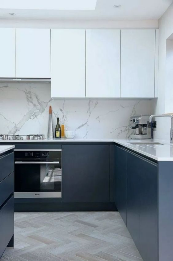 moderne Küche grifflose Schränke weiße Oberschränke marineblaue Unterschränke Küchenrückwand aus hellgrauem Marmor