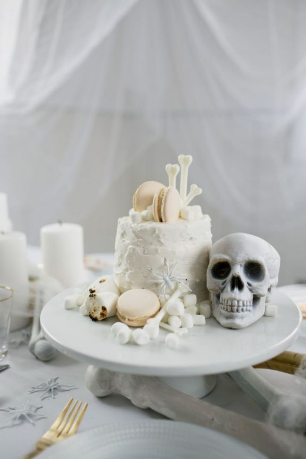 Weiße Halloween Deko Ideen auf dem Esstisch Etagere Totenkopf weiße Torte Knochen