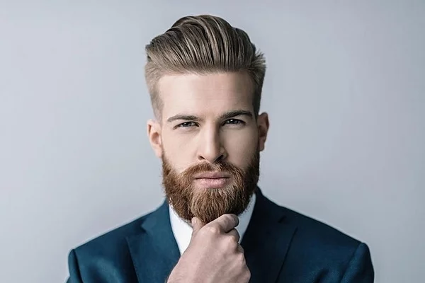ajunger Mann dunkelblondes Haar Bart ktuelle Bartfrisuren 2023 neue Trends mittellanger Bart