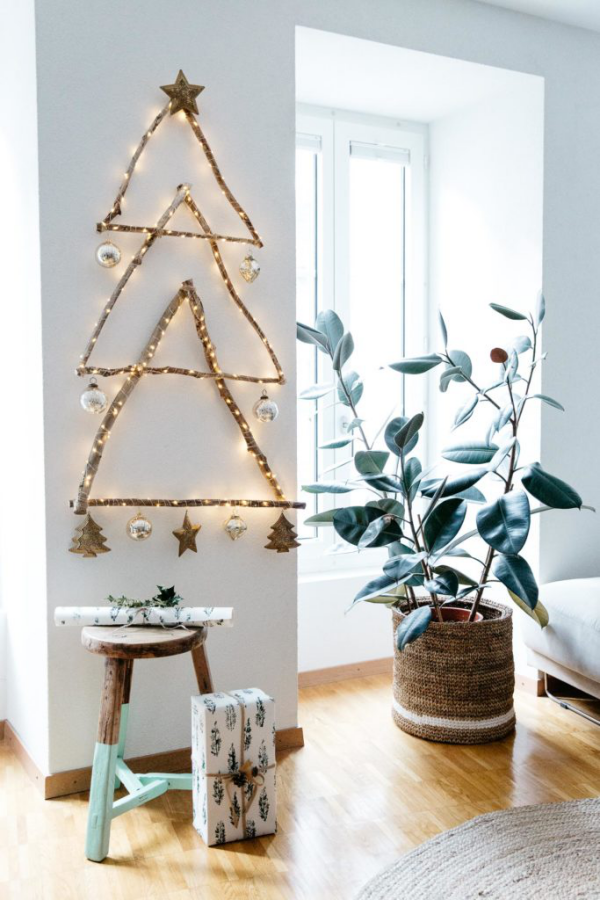 DIY Christbaum auf wenig Platz ein paar Äste Lichterkette in Form eines Weihnachtsbaum an der Wand
