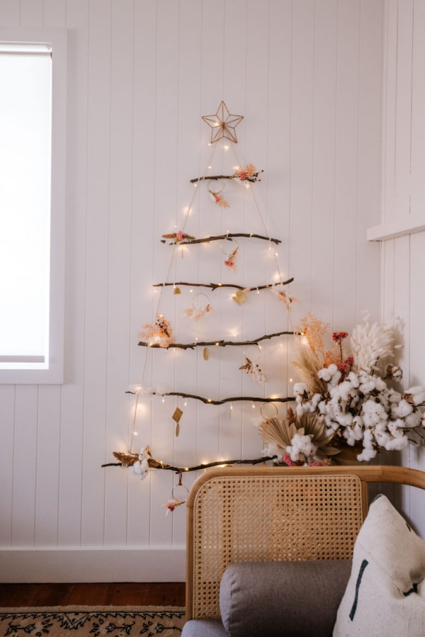 DIY Christbaum auf wenig Platz einfache Bastelidee mit Ästen und Lichterkette an der Wand ein Stern oben