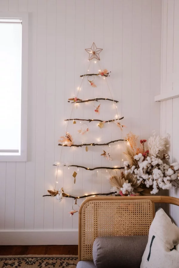 DIY Christbaum auf wenig Platz einfache Bastelidee mit Ästen und Lichterkette an der Wand ein Stern oben