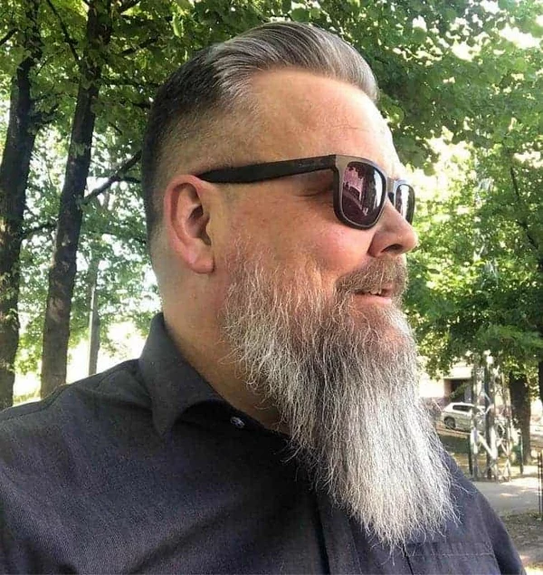 kurz geschnittenes graues Haar langer Bart gut gestylt Mann über 50 Jahre mit Sonnenbrille 
