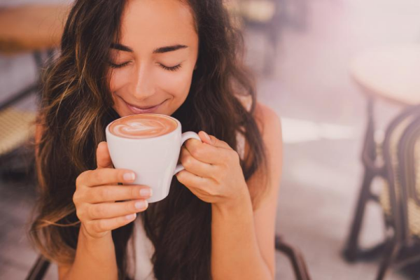Kaffee trinken überraschende Vorteile für die Gesundheit junge Frau beim Kaffeetrinken ein Lächeln im Gesicht