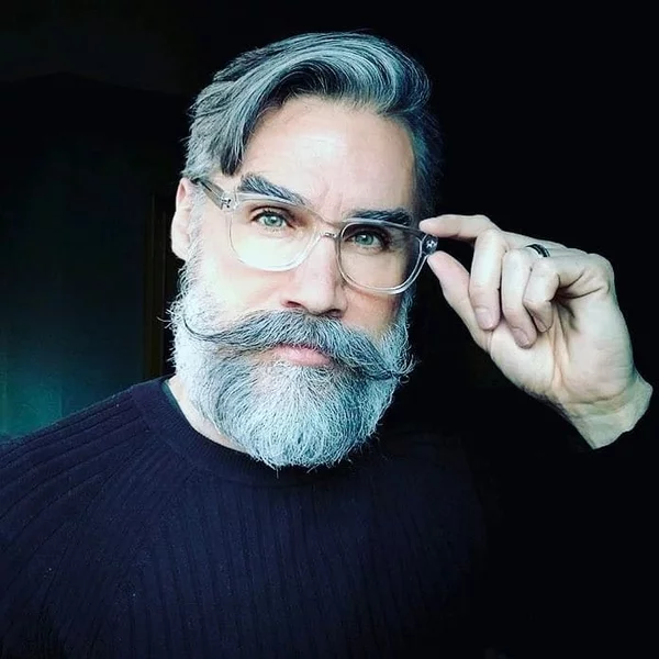 Männerhaarschnitte und Bartfrisuren für ältere Männer mit grauen Haaren sstilvoller Herr mit Scheitel Bart Schnurrbart und Brille 