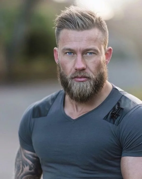 Aktuelle Bartfrisuren Wikinger Style Maennlichkeit zum Vorschein bringen junger guttrainerter Mann dunkelblondes Haar Bart