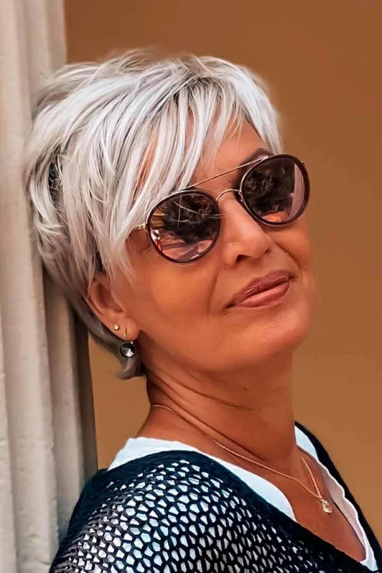 Frau über 50 mit silberblondem Pixie und Sonnenbrille 