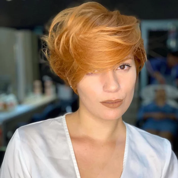 Bob mit Volumen Frisuren-Trend orangefarbenes Haar perfekt gestylt mit langem Pony zur Seite geföhnt